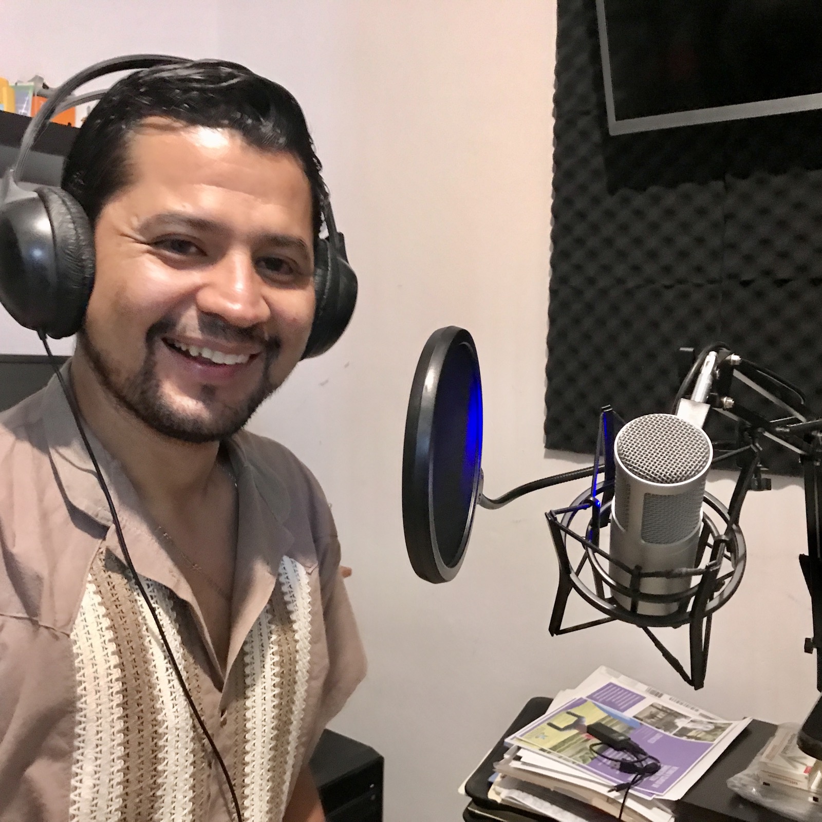 Invitado sonriendo junto al micrófono en cabina