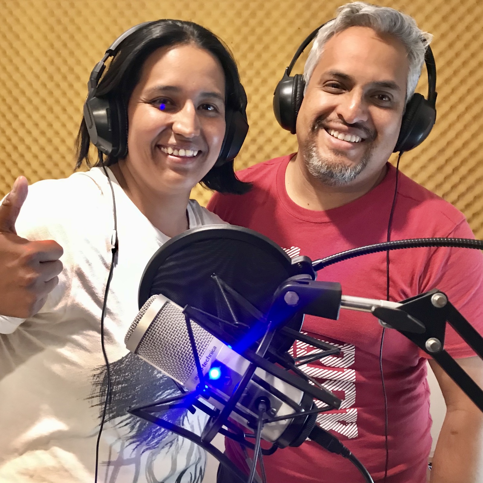 Invitada y conductor sonriendo en cabina con audífonos